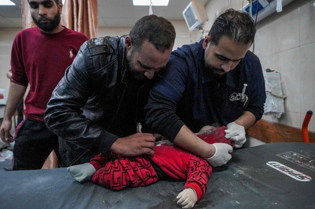 Un bebé sacado de los escombros de una casa tras un bombardeo israelí es atendido en el Hospital de los Mártires de Al Aqsa, en el centro de la franja de Gaza. Foto Afp 