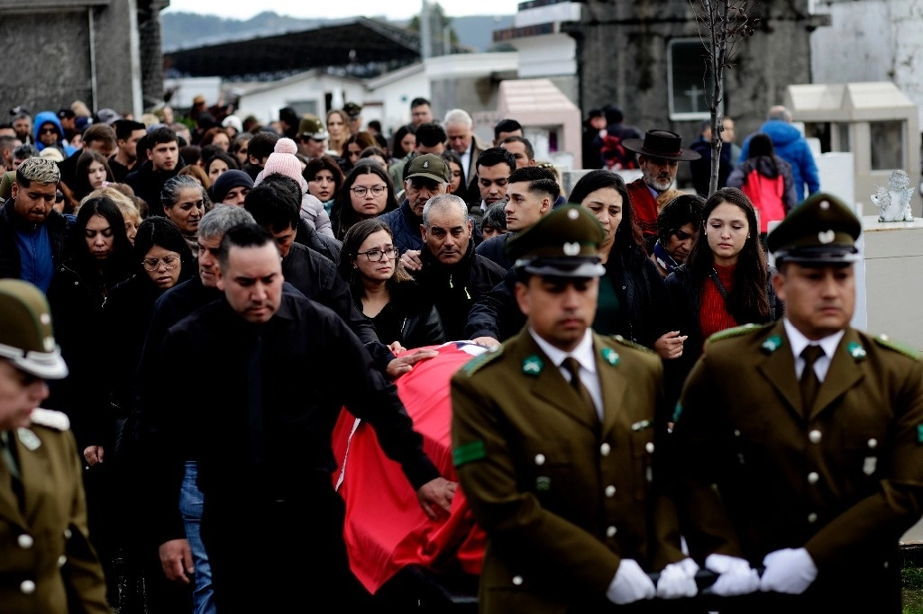Familiares y amigos acompañan el ataúd que contiene los restos del policía asesinado Carlos Cisterna durante una procesión fúnebre en Lebu, Chile, el 30 de abril de 2024. Foto Ap
