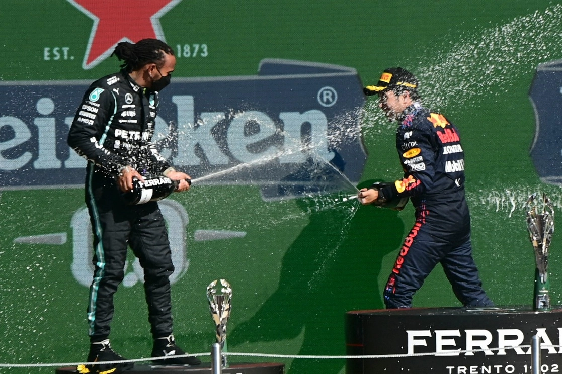 Lewis Hamilton (izquierda) y Checo Pérez festejan el segundo y tercer lugar en la Fórmula 1. Foto Pedro Pardo/ AFP
