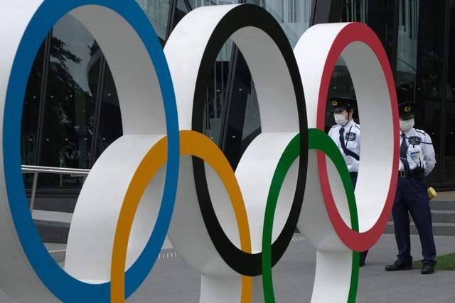 Agentes vigilan mientras inconformes preparan una protesta contra la celebración de los Juegos Olímpicos de Tokio. Foto Afp