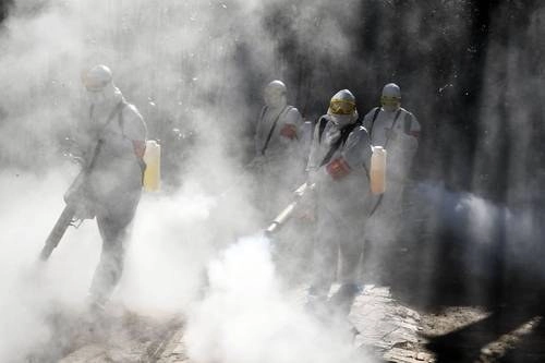 Equipo de saneamiento de la policía rocía desinfectante en la ciudad china de Bozhou para prevenir casos de coronavirus. Foto Afp / Archivo