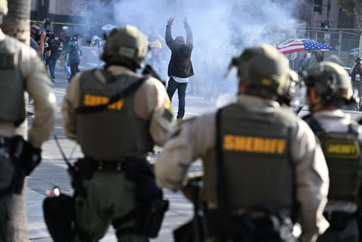 Un manifestante levanta las manos en medio de una nube de gas lacrimógeno en Los Ángeles, California, mientras las fuerzas del orden dispersan a los manifestantes, el 14 de junio de 2025.
