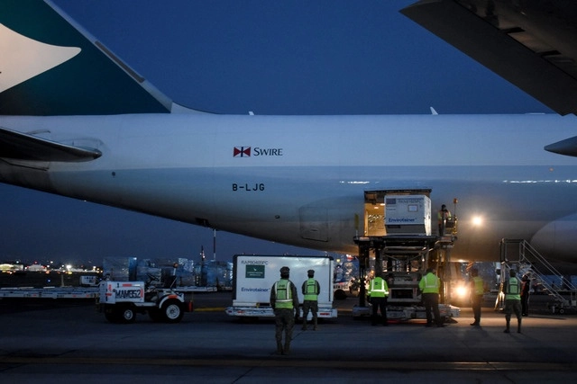Trabajadores descargan un contenedor con un nuevo embarque de la vacuna de la farmacéutica china CanSino Biologics contra el  coronavirus, en el Aeropuerto Internacional de la Ciudad de México, en imagen de antier. Foto Xinhua
