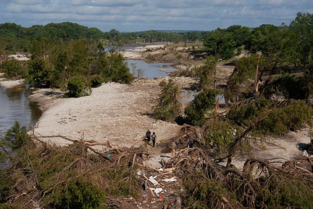 Equipos de búsqueda y rescate del Departamento de Bomberos de Kerrville caminan entre escombros tras la inundación cerca de las orillas del río Guadalupe en Kerrville, Texas, el 8 de julio de 2025. 
