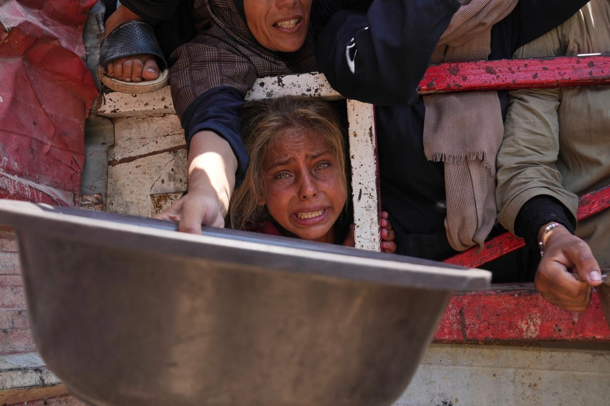 Gazatíes luchan por conseguir comida en una cocina comunitaria, en el norte del enclave. Foto 