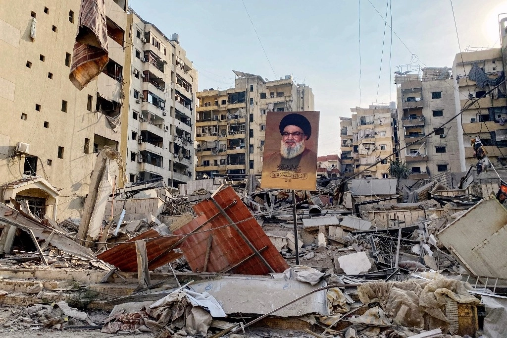 Un retrato del líder asesinado de Hezbolá, Hassan Nasrallah, se encuentra entre los escombros en el barrio de Rouweiss, un suburbio del sur de Beirut, ayer 10 de octubre de 2024, tras los ataques israelíes nocturnos. Foto AFP 