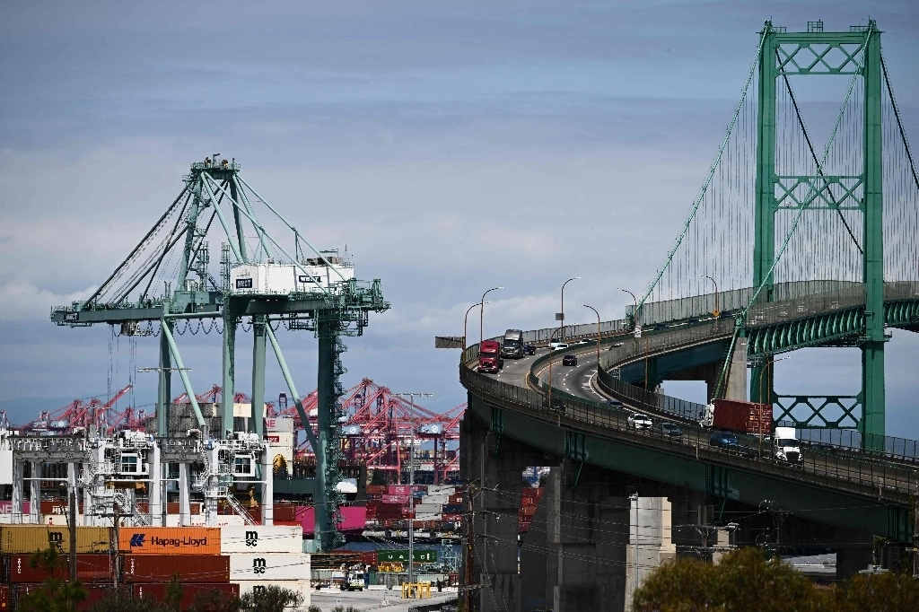 Camiones cruzan el puente Vincent Thomas, mientras se descargan contenedores de un buque en el puerto de Los Ángeles, California, en junio de 2023. Foto Afp