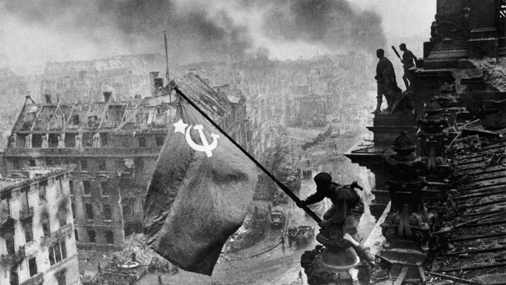 Un soldado soviético iza la bandera de la URSS en el Reichstag, imagen histórica que simboliza la caída de Berlín y la derrota del régimen nazi hace 80 años. Foto 