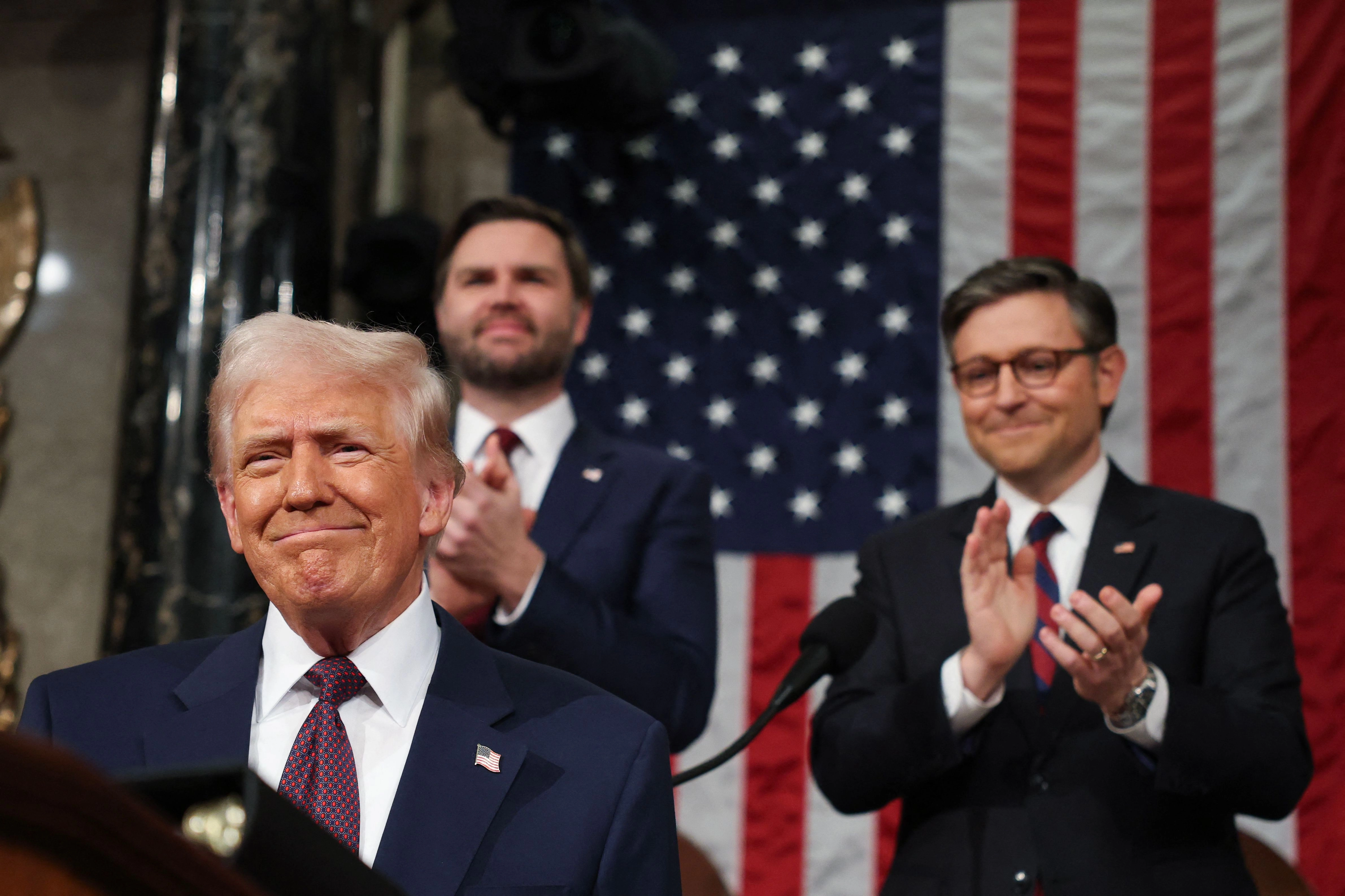 El líder de la Cámara de Representantes de Estados Unidos, Mike Johnson (a la derecha), y el vicepresidente, JD Vance, aplauden al presidente Trump antes de su mensaje al Congreso. Foto