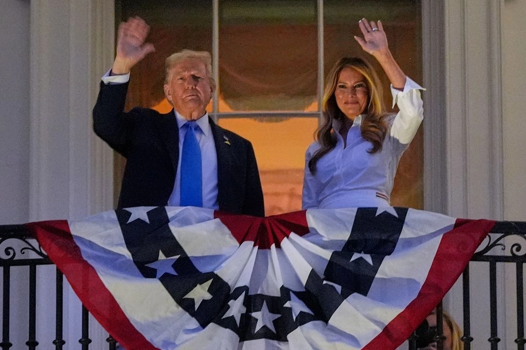 El presidente Donald Trump y su esposa Melania saludan desde el balcón Truman en la Casa Blanca, durante los festejos con fuegos artificiales por el 4 de julio. Foto 
