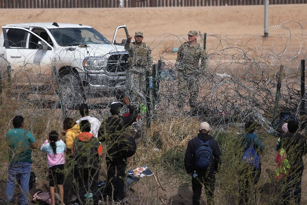 México SA.  Agentes de la Guardia Nacional de Texas impiden que migrantes crucen una valla con alambre de púas en El Paso después de cruzar el Río Grande desde Ciudad Juárez. Foto Afp