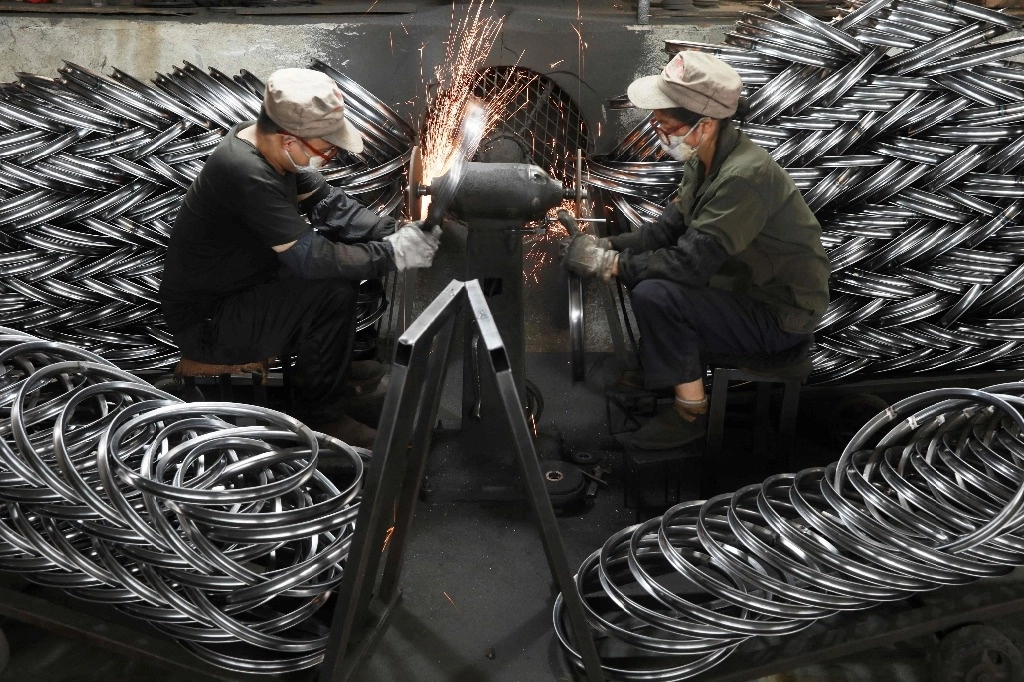 Fábrica de piezas para bicicletas de exportación en Hangzhou, en la provincia de Zhejiang. La economía de China avanzará 5 por ciento en el presente año, prevé el FMI. Foto Afp