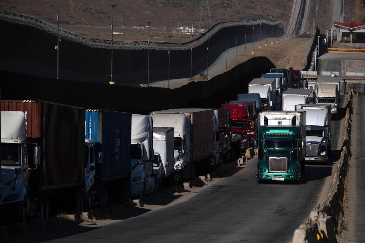 Tractocamiones cargados de diversas mercancías hacen fila para cruzar a Estados Unidos por la garita de Mesa de Otay, en Tijuana, Baja California. El presidente estadunidense, Donald Trump, pospuso el aumento de aranceles a México. 