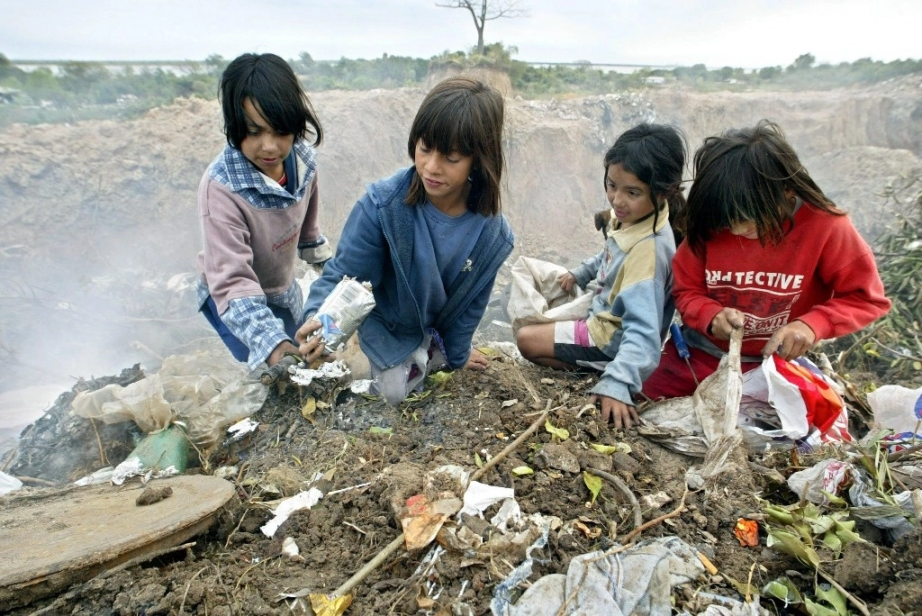 Niños buscan cartón en un basurero cercano al río Paraná, en las afueras de la ciudad de Corrientes, Argentina, donde la pobreza afecta a más de la mitad de la población. Foto Afp