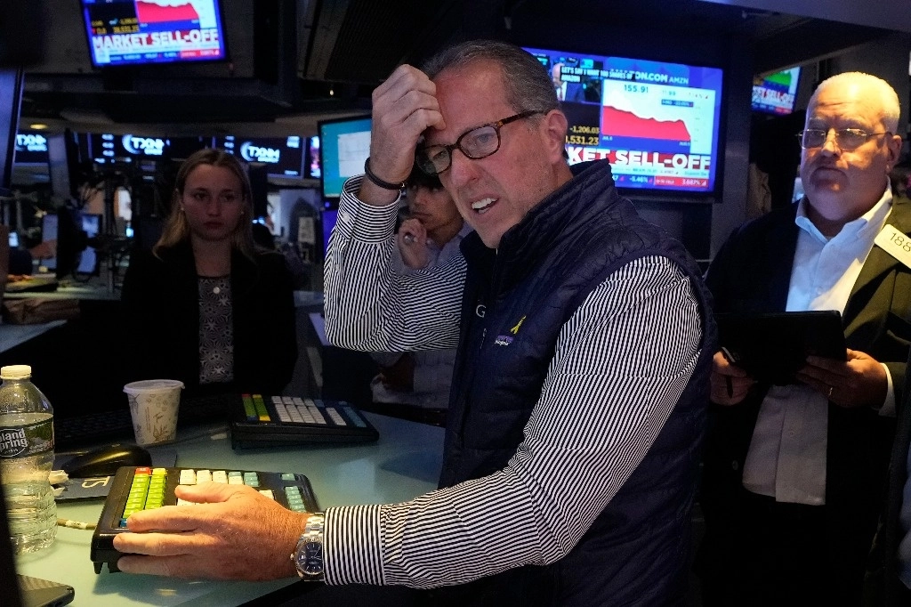 Glenn Carell, especialista en operaciones en el piso de remates de la Bolsa de Valores de Nueva York, durante la accidentada sesión de ayer, marcada por los temores de que la desaceleración de la economía estadunidense empeore y siga afectando a los mercados financieros del mundo. Foto Ap 