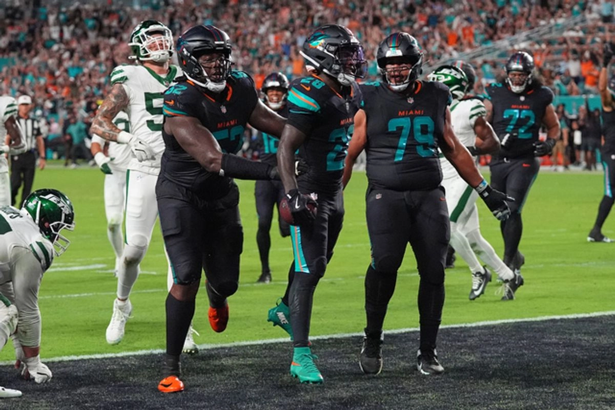 Los jugadores de los Delfines de Miami, Patrick Paul (izq), De'Von Achane (c) y Larry Borom (der) celebran después de que Achane corrió el balón para una anotación. Foto 