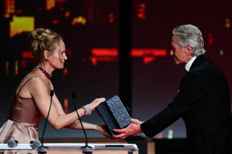 "A Cannes y a toda Francia, querría abrazarla desde el fondo de mi corazón", dijo en francés Michael Douglas, antes de que Uma Thurman le entregara el premio, en el marco del Festival Internacional de Cine de Cannes, el 16 de mayo de 2023. Foto Afp 
