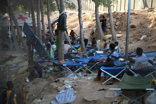 Migrantes descansan en un campo en la isla italiana de Lampedusa, en imagen de ayer. Foto Afp 