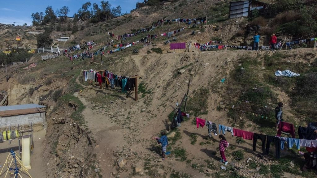 Migrantes que se refugiaron en el albergue Embajadores de Jesús, ubicado en el Cañón del Alacrán, en Tijuana, Baja California, luego de ser desalojados del campamento El Chaparral por elementos de la Guardia Nacional y policías municipales el domingo pasado, tienden su ropa en terrenos aledaños. Foto Omar Martínez / La Jornada Baja California