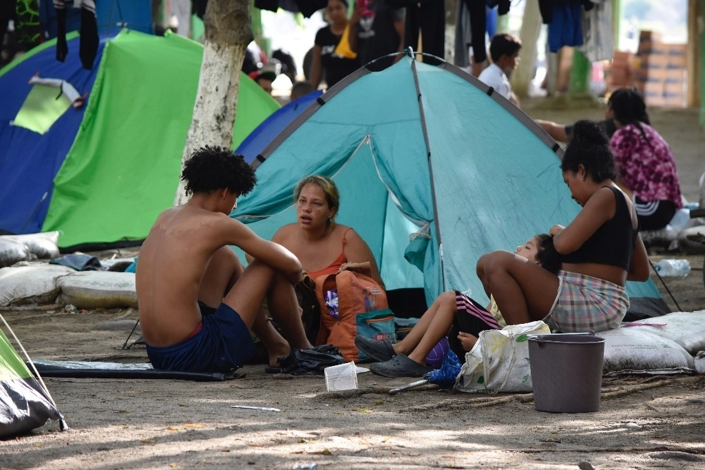 Migrantes sudamericanos aguardan en la ribera del río Suchiate en espera de que el INM les brinde autobuses para seguir su camino hacia EU. Foto Édgar H. Clemente
