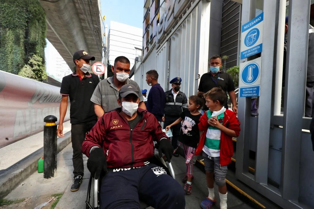 Integrantes de la caravana migrante salen de las instalaciones de la CNDH, tras asistir a una reunión en la dependencia, donde a algunos se les realizó una revisión médica, en la Ciudad de México, el 15 de diciembre de 2021. Foto Roberto García Ortiz

