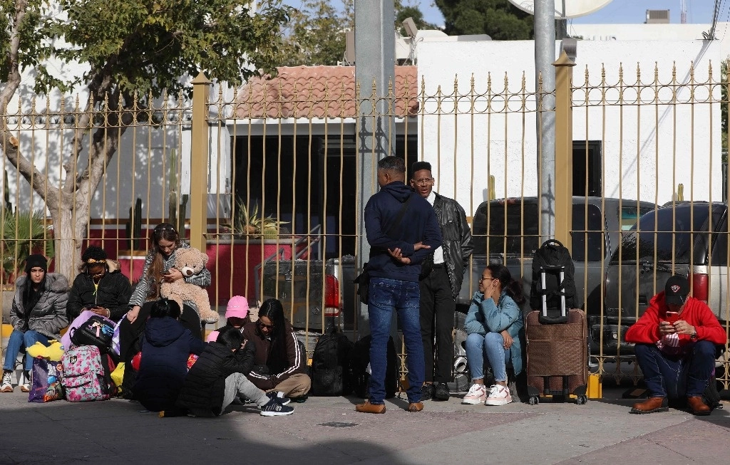 Migrantes que buscan cita para pedir asilo en EU hacen fila cerca del puente internacional Paso del Norte, en Ciudad Juárez, Chihuahua. Foto Afp 