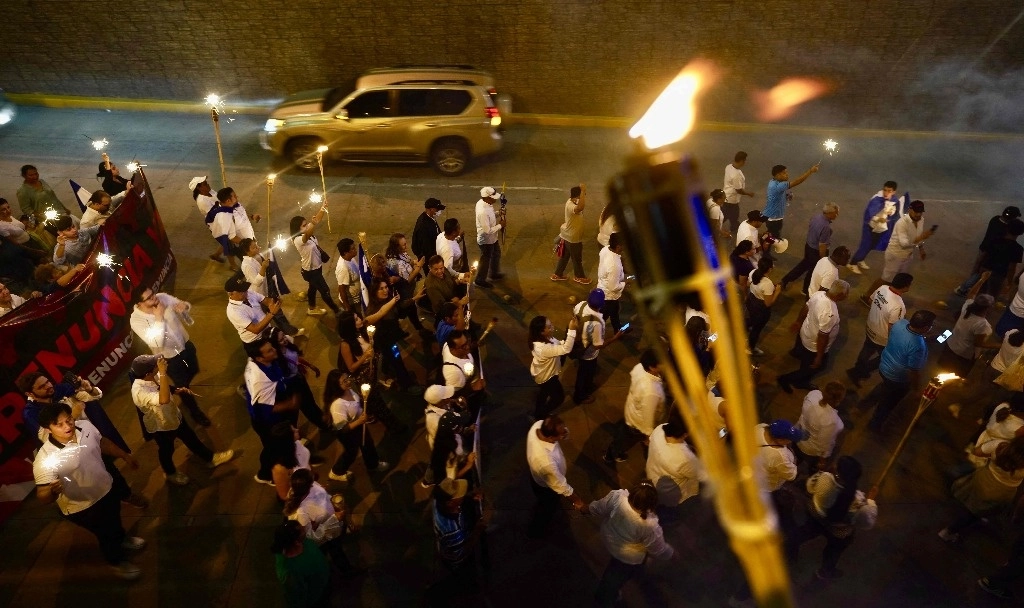 Miles de opositores de derecha marcharon el viernes con antorchas en Honduras contra el gobierno de la presidenta hondureña Xiomara Castro por cancelar el tratado de extradición con Estados Unidos que permitió el encarcelamiento de medio centenar de narcotraficantes. Foto Afp