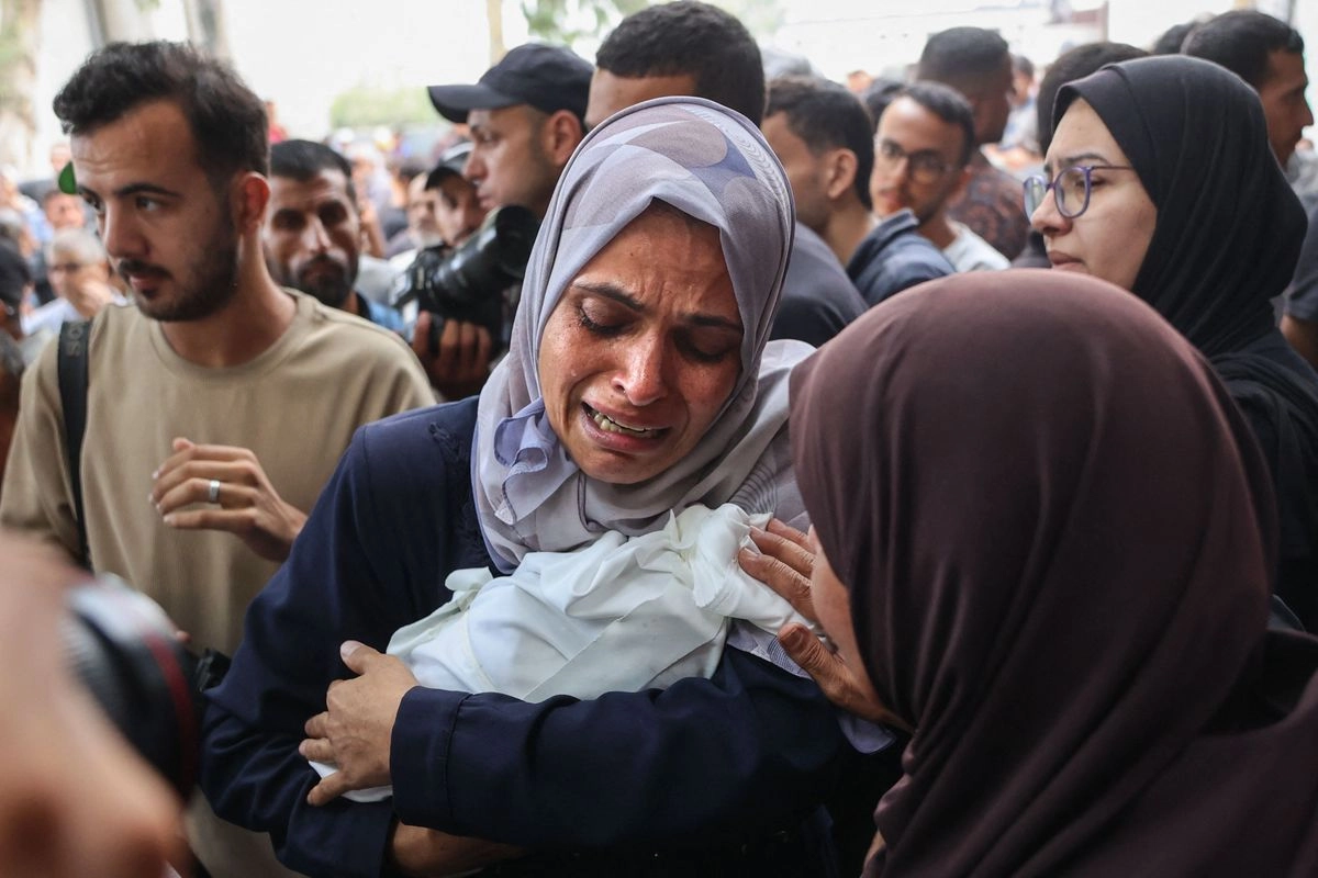  Una mujer gazatí sostiene el cadáver de un bebé asesinado por los bombardeos de Israel en la ciudad de Gaza, momentos antes de que el cortejo fúnebre partiera del hospital Al Shifa.