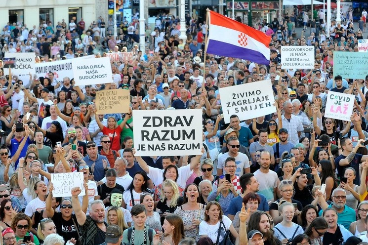 Manifestantes sostienen varios carteles durante una protesta contra las medidas del gobierno contra el Covid-19 en el centro de Zagreb, Croacia. Foto AP