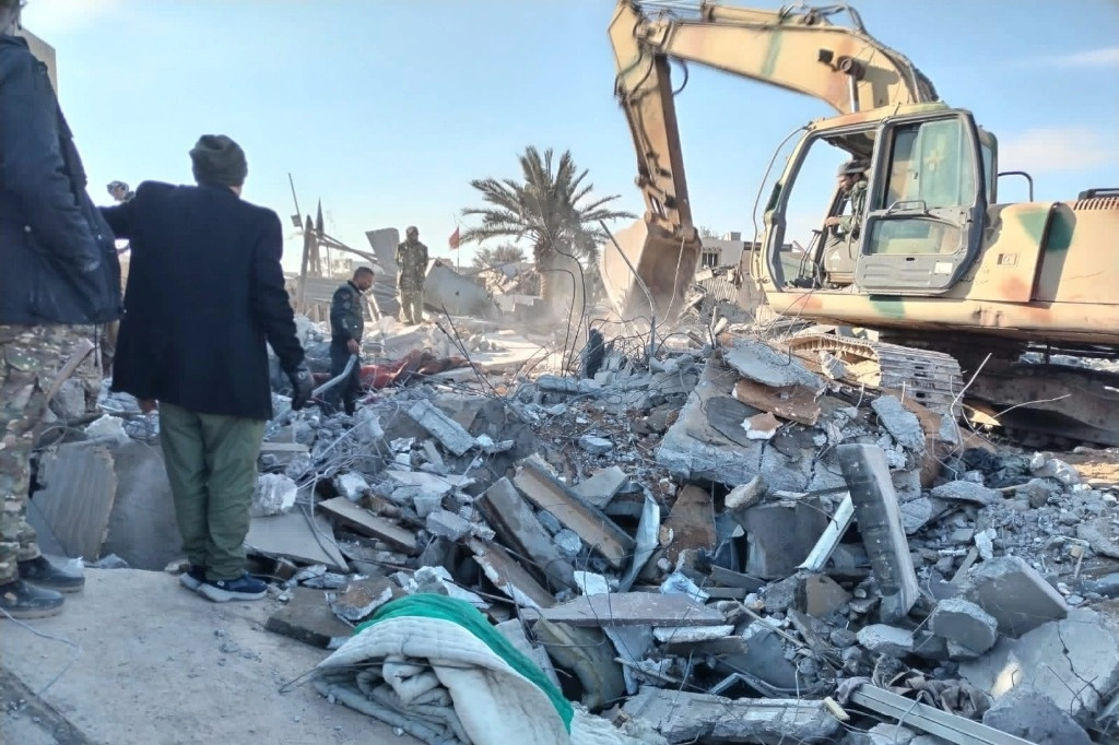 Miembros de las Fuerzas de Movilización Popular Chiíta iraquíes buscan sobrevivientes en los escombros después de un ataque aéreo estadunidense en Al Qaim, Irak. Foto Ap 




