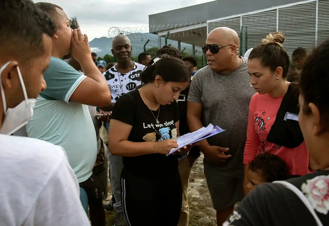 Personal del INM entrega formulario de estancia de 30 días por razones humanitarias en Chiapas. Foto Afp