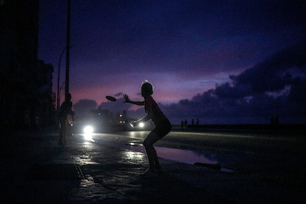 Habitantes de La Habana, Cuba, juegan con un 'frisbee' en medio del apagón masivo, el 18 de octubre de 2024. Foto Ap