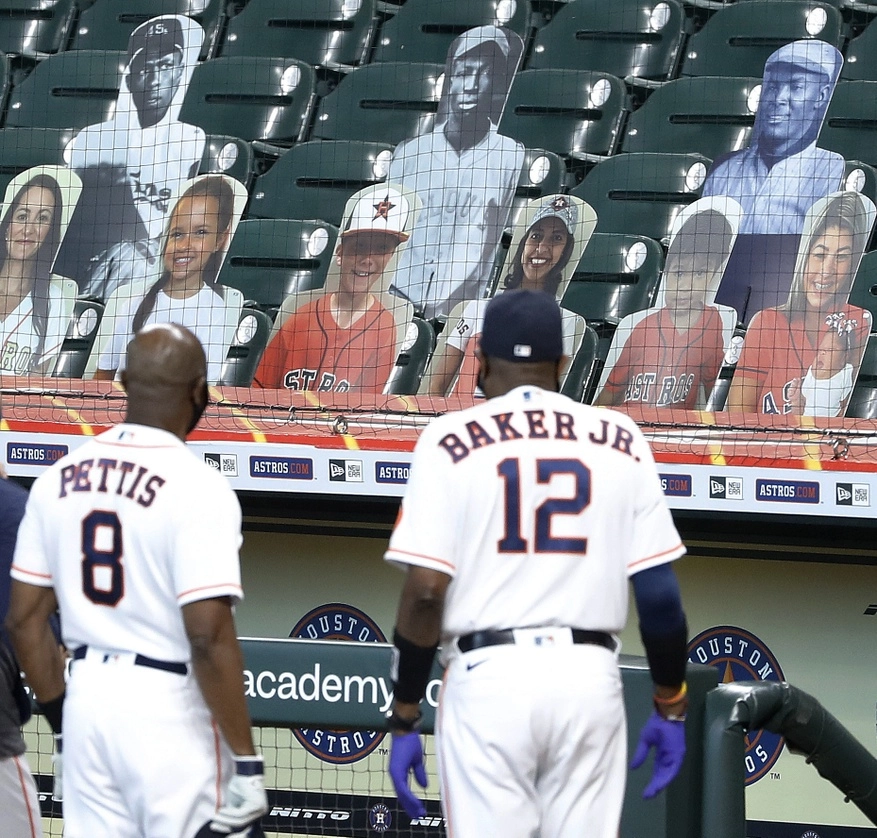  El entrenador de tercera base de los Astros de Houston Gary Pettis y el manager Dusty Baker Jr., miran hacia las gradas recortes de fotografías de exjugadores de la Liga Negra. Foto Ap
