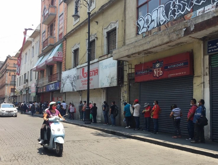 Fila de consumidores esperando entrar a comprar a los negocios abiertos ubicados en algunas calles del Centro Histórico, aún dentro de la fase 3 de la contingencia sanitaria. Foto Guillermo Sologuren