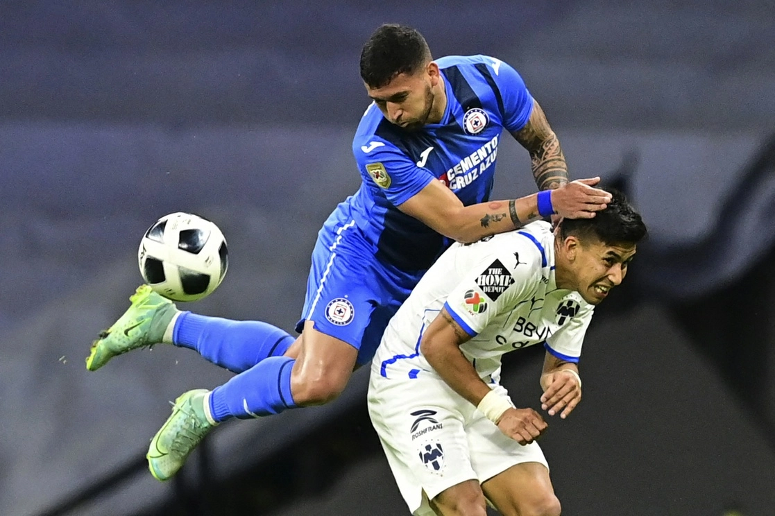 El defensa de Cruz Azul, Juan Escobar, y el mediocampista rayado, Maximiliano Meza, disputan un balón. Foto Afp