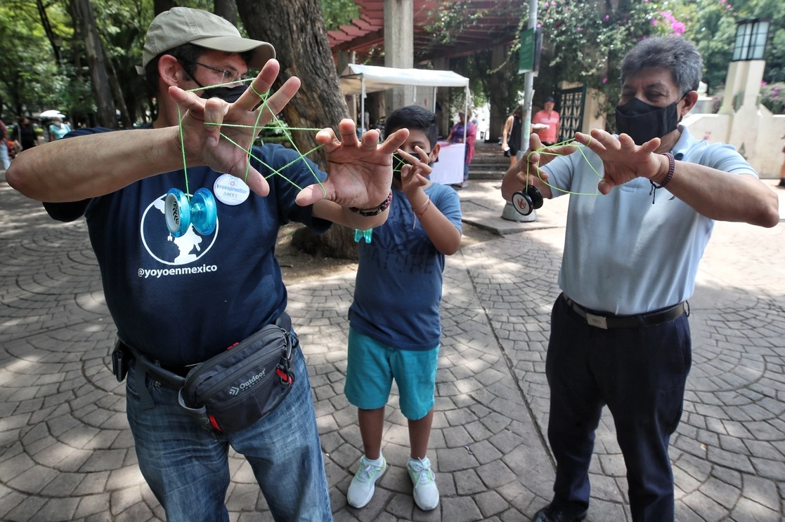 Padre e hijo reciben clases para realizar suertes con el yoyo en el parque Condesa, en la Ciudad de México. Foto Marco Peláez