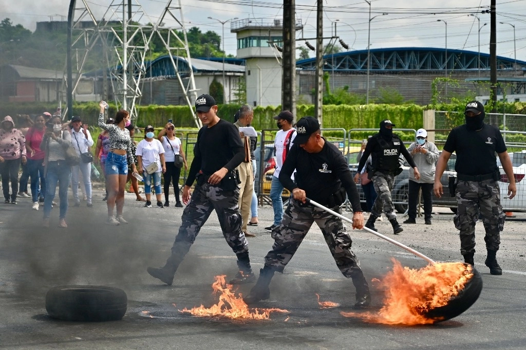 Policías despejan el área durante una protesta de familiares de los internos, en los alrededores de la prisión de Guayaquil, en Ecuador. Foto Afp