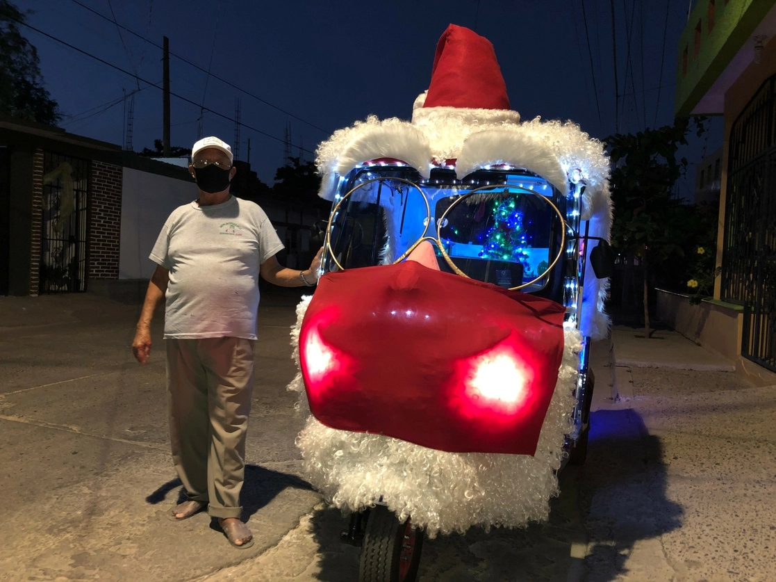 El conductor de un mototaxi recorre las calles de Juchitán con la unidad disfrazada de Santa Claus con cubreboca. Foto Diana Manzo