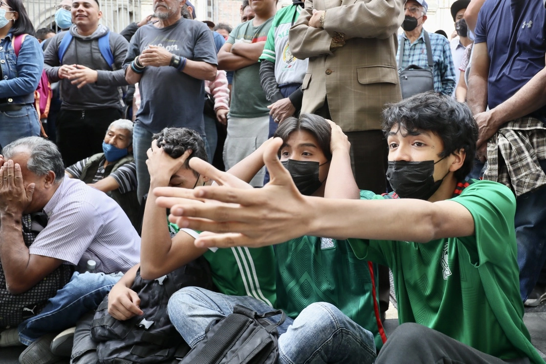 Aficionados al futbol ven el partido de la Selección Mexicana contra Arabia Saudita, durante la Copa Mundial de Qatar, al exterior de un negocio en la avenida Madero, en el Centro Histórico capitalino, el 30 de noviembre de 2022. Foto Roberto García Ortiz 
