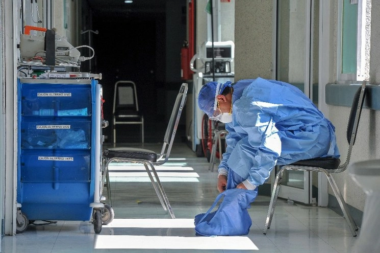 Un médico se ajusta su uniforme en un hospital de Monterrey. Foto Afp