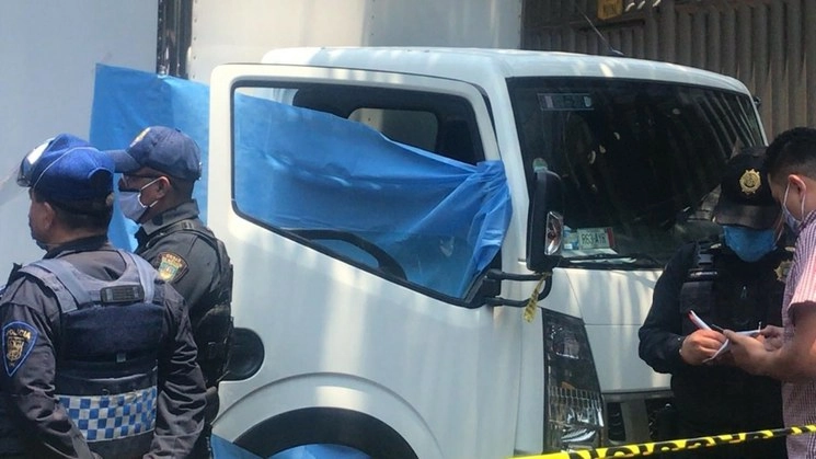 Policías capitalinos resguardan la camioneta donde esta tarde fue asesinada una mujer que se resistió a un asalto. Foto La Jornada