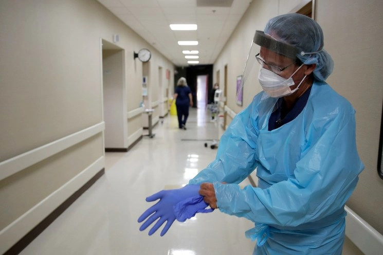 Una enfermera colocándose su traje especial de protección. Foto Ap