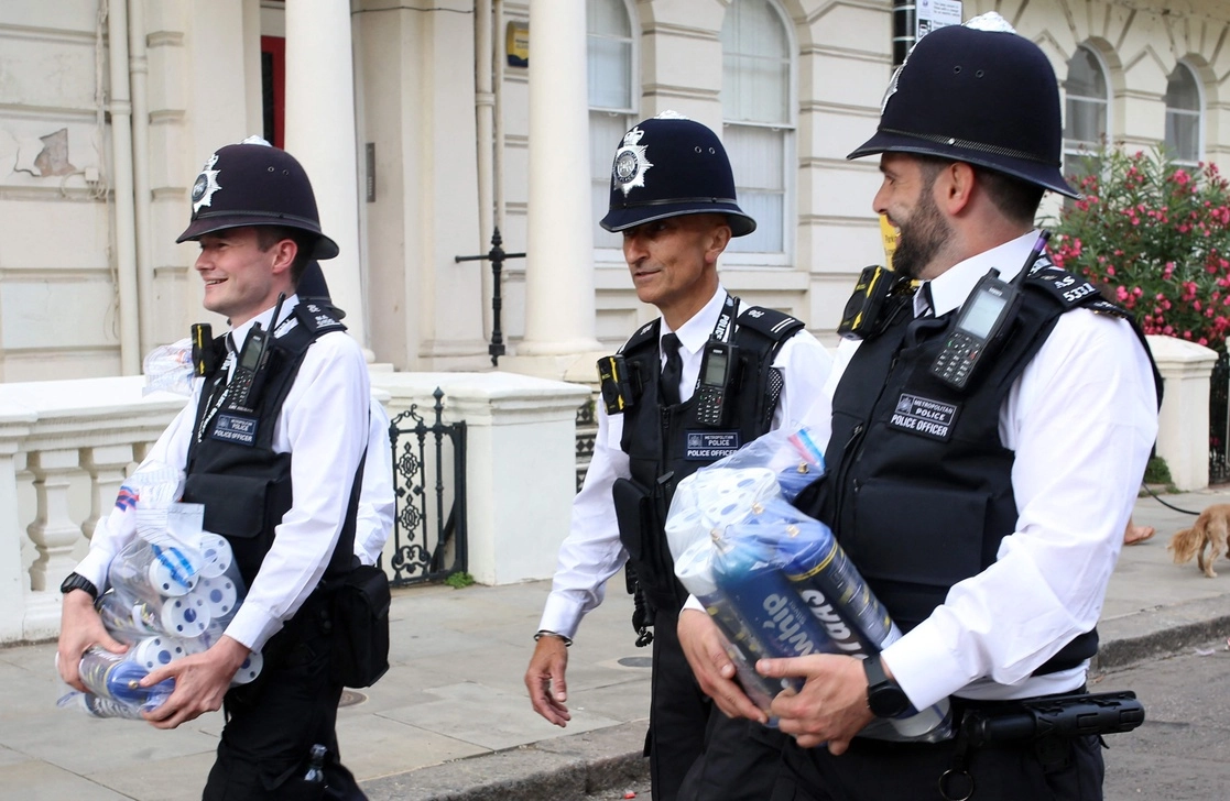 Policías trasladan “gas de la risa” confiscado en el Festival de Notting Hill, el 29 de agosto de 2022. Foto Afp 