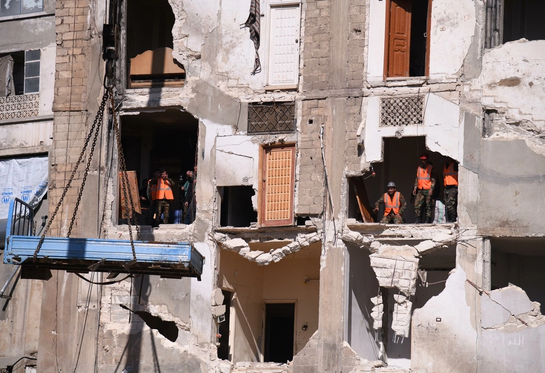 Trabajadores trasladan muebles de un edificio residencial que fue dañado durante el terremoto del 6 de febrero pasado, en Hama, en el centro de Siria. En esta provincia murieron hoy 10 civiles por explosión de minas antipersona. Foto Xinhua