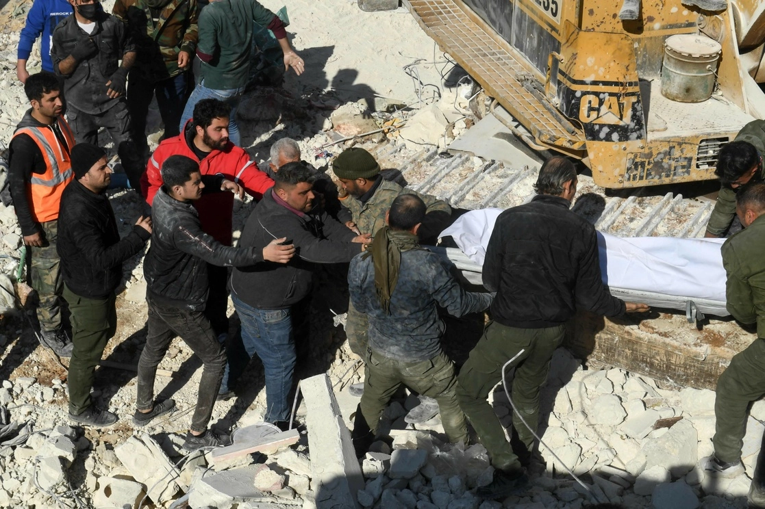 Rescatistas desalojan el cadáver de una de las víctimas mortales del edificio colapsado en Alepo, Siria. Foto Afp 