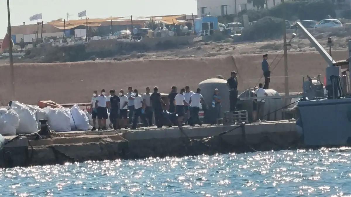 Oficiales de la Guardia Costera italiana se movilizan en el puerto de Lampedusa, luego de que un barco con casi 100 migrantes naufragara frente a la isla italiana, causando varias muertes y dejando a una docena de desaparecidos, el 13 de agosto de 2025. Foto 