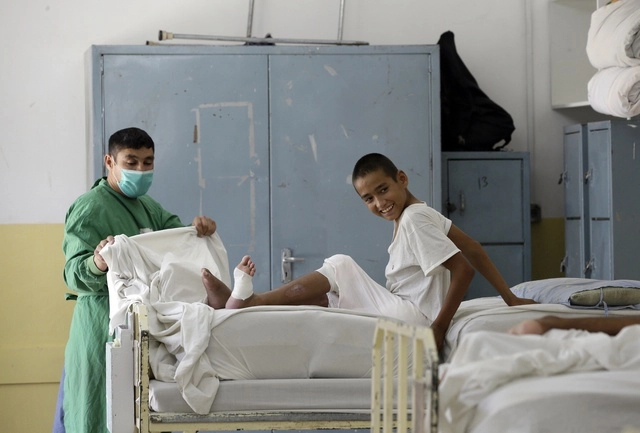 Un niño afgano recibe tratamiento médico en un centro de rehabilitación física de la Cruz Roja, tras ser herido durante los combates entre los talibanes y las fuerzas de seguridad en Kabul. Foto Ap 