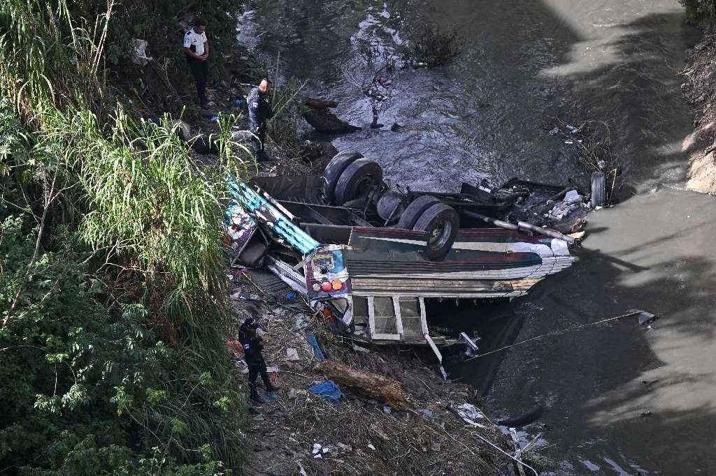 Los bomberos trabajan en el lugar de un accidente en el que un autobús cayó por un barranco en la Ciudad de Guatemala el 10 de febrero de 2025. Foto Afp