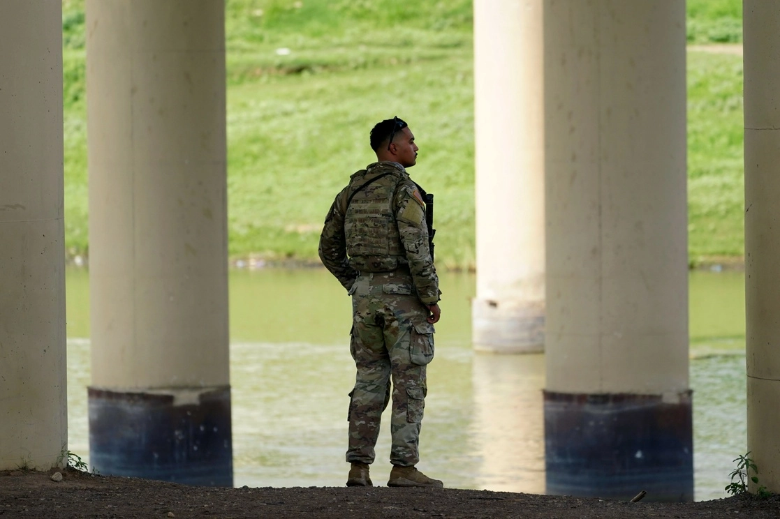 Un miembro de la Guardia Nacional de Texas mira a través del Río Grande hacia México desde los EU, en Eagle Pass, Texas. Foto Ap