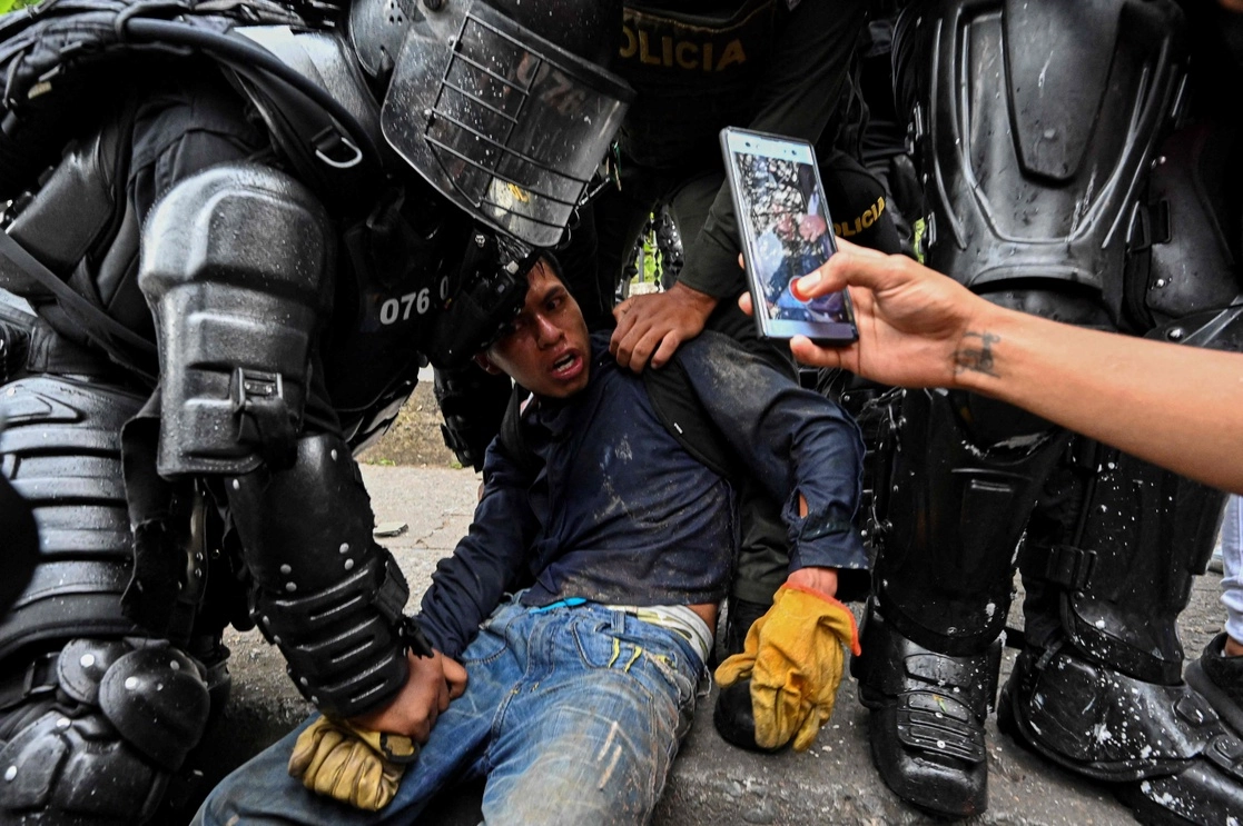 Policías colombianos arrestan a un manifestante durante una protesta antigubernamental en Cali, el 10 de mayo de 2021. Foto Afp 
